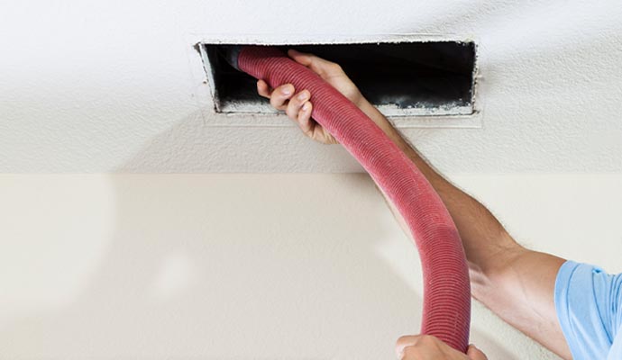 Person cleaning air duct