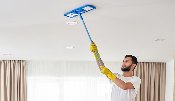 a professional cleaning a ceiling