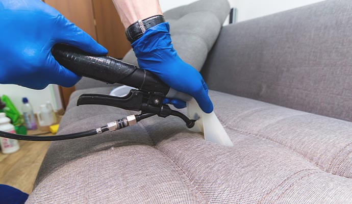 a professional cleaning upholstery using equipment