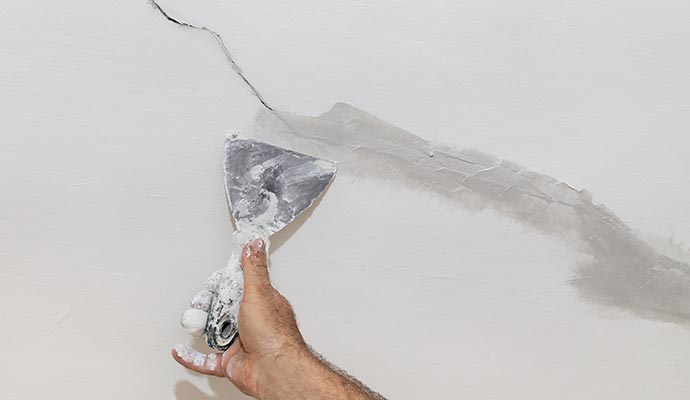 A professional repairing a damaged wall