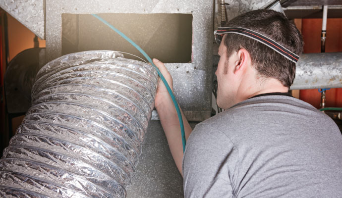 A professional technician cleaning an air duct