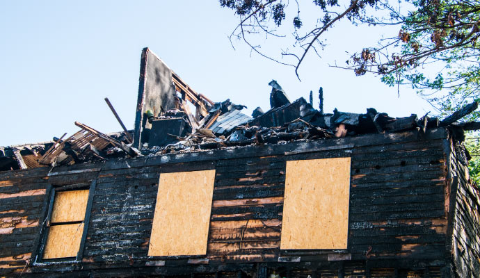 boarded-up windows in a fire damaged house