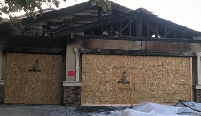 Burned house with boarded-up garage doors