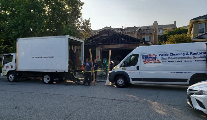 Teampulido restoration vehicle in front of a fire damaged residential building