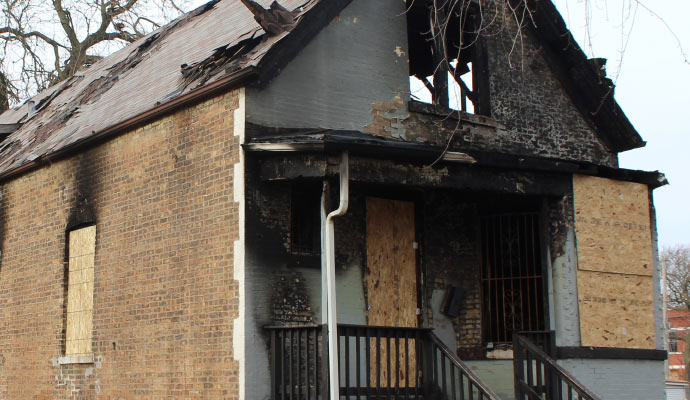 boarded-up windows in a fire damaged house