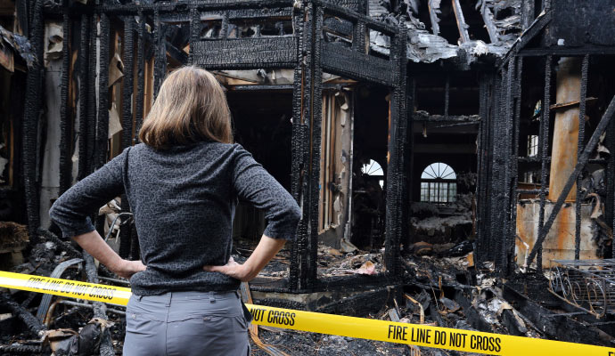 a person inspecting fire damaged area