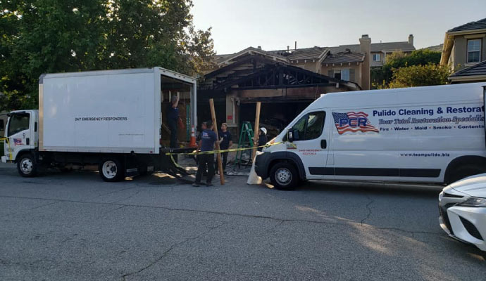 Teampulido fire damage restoration truck in front of a fire damaged house