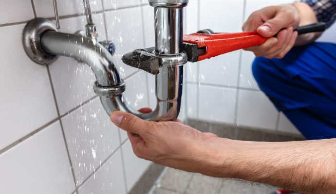 Plumber fixing broken pipe